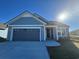 Charming single-story home with blue siding, a gray garage door, and manicured landscaping at 1249 Crested Iris Way, North Myrtle Beach, SC 29582