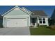 Charming single-Gathering home features a 2 car garage, well-manicured lawn, and a light blue exterior at 1249 Crested Iris Way, North Myrtle Beach, SC 29582