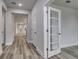 Hallway featuring wood-look flooring, neutral wall colors, and decorative glass doors at 1249 Crested Iris Way, North Myrtle Beach, SC 29582