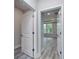 Hallway with gray wood floors and entryways to rooms with neutral paint and white trim at 1249 Crested Iris Way, North Myrtle Beach, SC 29582