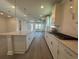 A kitchen features an island, stainless appliances, granite countertops, and hardwood floors at 1249 Crested Iris Way, North Myrtle Beach, SC 29582