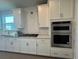 Bright kitchen featuring white cabinets, stainless steel appliances, and a modern gas cooktop at 1249 Crested Iris Way, North Myrtle Beach, SC 29582