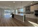 Open-concept kitchen featuring a large island, stainless steel appliances, and sliding glass doors at 1249 Crested Iris Way, North Myrtle Beach, SC 29582
