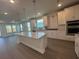 A kitchen features an island, stainless appliances, granite countertops, and hardwood floors at 1249 Crested Iris Way, North Myrtle Beach, SC 29582