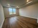 Bright bedroom featuring hardwood floors, recessed lighting, and a large window at 1253 Crested Iris Way, North Myrtle Beach, SC 29582