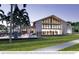 A modern clubhouse building with a gable roof, large windows, and front lawn with palm trees and a stone fence at 1253 Crested Iris Way, North Myrtle Beach, SC 29582
