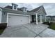 Exterior shot featuring a large two-car garage and concrete driveway leading to a charming gray home at 1257 Crested Iris Way, North Myrtle Beach, SC 29582