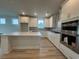 Bright kitchen features white cabinetry, quartz countertops, stainless steel appliances and a large island at 1257 Crested Iris Way, North Myrtle Beach, SC 29582