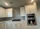 Modern kitchen features stainless steel appliances, custom white cabinets, and a stylish backsplash at 1257 Crested Iris Way, North Myrtle Beach, SC 29582