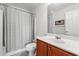 Cozy bathroom with cherry-stained vanity, gray tile, and shower-tub combo with shower curtain at 1298 Harvester Circle # 1298, Myrtle Beach, SC 29579