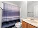 Cozy bathroom featuring a shower with stylish striped curtain, toilet, sink and wood cabinet at 1298 Harvester Circle # 1298, Myrtle Beach, SC 29579