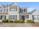 Charming two-story townhouse featuring neutral siding, black shutters, and manicured landscaping at 1298 Harvester Circle # 1298, Myrtle Beach, SC 29579