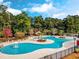 Beautiful community pool surrounded by mature trees, ample lounge chairs and a small red building at 1298 Harvester Circle # 1298, Myrtle Beach, SC 29579