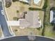 A bird's eye view of a tan roofed home with manicured front yard, driveway, and a pool on the property at 14 Cobblestone Dr., Pawleys Island, SC 29585