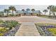 Exterior view of a clubhouse featuring palm trees and colorful flowers at 14 Cobblestone Dr., Pawleys Island, SC 29585