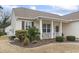 Close-up view of the front yard and cozy porch with white columns of a home with neutral siding at 14 Cobblestone Dr., Pawleys Island, SC 29585