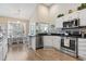 Open-concept kitchen features stainless steel appliances, granite counters, white cabinetry, and an adjacent dining area at 14 Cobblestone Dr., Pawleys Island, SC 29585