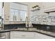 Kitchen sink area featuring granite countertops, decorative backsplash, stainless steel appliances and modern fixtures at 14 Cobblestone Dr., Pawleys Island, SC 29585