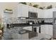 Kitchen boasts white cabinets, stainless steel appliances, granite countertops, decorative tile backsplash, and modern fixtures at 14 Cobblestone Dr., Pawleys Island, SC 29585