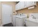 Well-organized laundry room featuring a washer, dryer, sink, and ample cabinet storage at 14 Cobblestone Dr., Pawleys Island, SC 29585