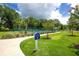 Outdoor pickleball courts surrounded by lush landscaping and greenery, with signage at 141 Hartland Dr. # 5-C, Myrtle Beach, SC 29572