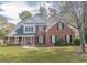 Traditional brick home featuring a manicured lawn, a covered porch, and mature trees at 1427 Mcmaster Dr., Myrtle Beach, SC 29575