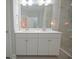 Modern bathroom featuring double sinks with white cabinetry, and a glass-enclosed shower with tiled walls at 148 Splendor Circle, Murrells Inlet, SC 29576