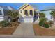 Charming yellow coastal home featuring a 2-car garage, palm trees, and a well-manicured lawn at 148 Splendor Circle, Murrells Inlet, SC 29576