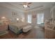 Well-lit main bedroom with a decorative ceiling fan, tray ceiling, cozy seating, and bright windows at 148 Splendor Circle, Murrells Inlet, SC 29576
