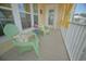 Cozy porch featuring green Adirondack chairs, side table with flowers, and yellow curtains for a relaxing outdoor space at 148 Splendor Circle, Murrells Inlet, SC 29576
