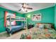 Bright bedroom features a bunk bed and a queen sized bed with colorful bedding and a ceiling fan at 1551 Victoria Ln., Myrtle Beach, SC 29577