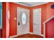 Inviting foyer with a decorative front door, hardwood flooring, and brightly painted coral walls at 1551 Victoria Ln., Myrtle Beach, SC 29577