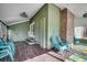 Cozy screened porch with comfortable seating, ceiling fan, and rustic brick accents at 1551 Victoria Ln., Myrtle Beach, SC 29577