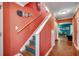 Stylish staircase features hardwood treads, vibrant coral walls, and unique beach-themed decor at 1551 Victoria Ln., Myrtle Beach, SC 29577
