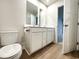 Bathroom features a double sink vanity with white cabinetry and modern fixtures over wood look flooring at 157 B Villa Grande St. # B, Myrtle Beach, SC 29579