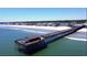 Panoramic aerial view of a fishing pier extending into the ocean and sandy beachfront homes at 160 Hoffman Park Dr. # 13, Myrtle Beach, SC 29588