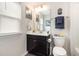 Well-lit bathroom featuring a vanity with a dark cabinet, a toilet, and decorative towels at 1881 Moonseed Dr., Longs, SC 29568
