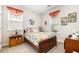 Cozy bedroom featuring a wood-framed bed with colorful bedding and two windows with decorative curtains at 1881 Moonseed Dr., Longs, SC 29568