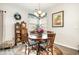 Cozy dining area featuring a round wooden table, floral accents, and soft natural light from the window at 1881 Moonseed Dr., Longs, SC 29568