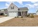 Charming home featuring a two-car garage, inviting front porch and manicured lawn in a friendly neighborhood at 1881 Moonseed Dr., Longs, SC 29568