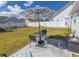 The backyard offers a charming patio area with stylish outdoor seating, perfect for relaxation and entertaining under a striped umbrella at 217 Sienna Dr., Little River, SC 29566