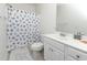 Cozy bathroom featuring a seashell themed shower curtain, white vanity, and neutral tile flooring at 225-B Dogwood Dr. N, Murrells Inlet, SC 29576