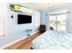 Coastal bedroom features light blue walls, a surfboard, and a sliding glass door leading to a balcony at 225-B Dogwood Dr. N, Murrells Inlet, SC 29576