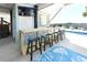 Covered outdoor bar area next to the pool with stools and a mounted television for entertainment at 225-B Dogwood Dr. N, Murrells Inlet, SC 29576