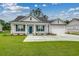 Charming single-story home with light gray siding, blue shutters, manicured lawn, and attached two-car garage at 227 Six Mile Creek Dr., Georgetown, SC 29440