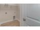 Bright laundry room with wood-look vinyl flooring, wire rack shelving, and utility connections at 227 Six Mile Creek Dr., Georgetown, SC 29440