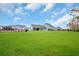Large backyard with green lawn area and houses, offering privacy and space for outdoor enjoyment at 2418 Goldfinch Dr., Myrtle Beach, SC 29577
