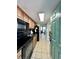 Galley style kitchen with black appliances and wood cabinets that opens to the dining and living room at 2710 N Ocean Blvd. # 1038, Myrtle Beach, SC 29577
