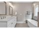 Bright bathroom featuring double sinks, modern fixtures, and a standalone tub at 3065 Moss Bridge Ln., Myrtle Beach, SC 29579