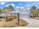 Charming home featuring a welcoming entrance, a well-manicured lawn, and a stylish grey and white color scheme at 3065 Moss Bridge Ln., Myrtle Beach, SC 29579